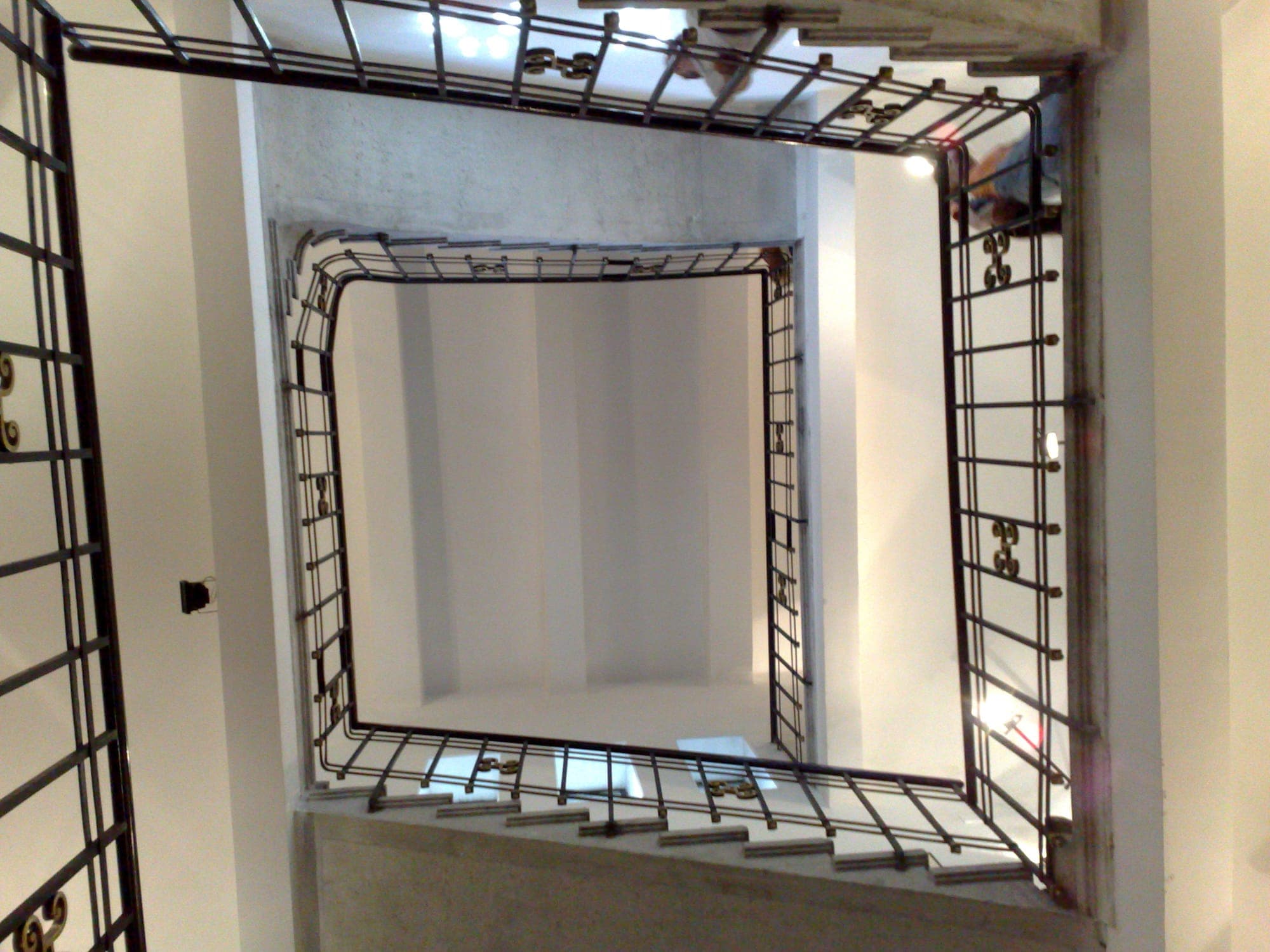 The arch's inner staircase seen from above, with its stone steps and black metal balustrade