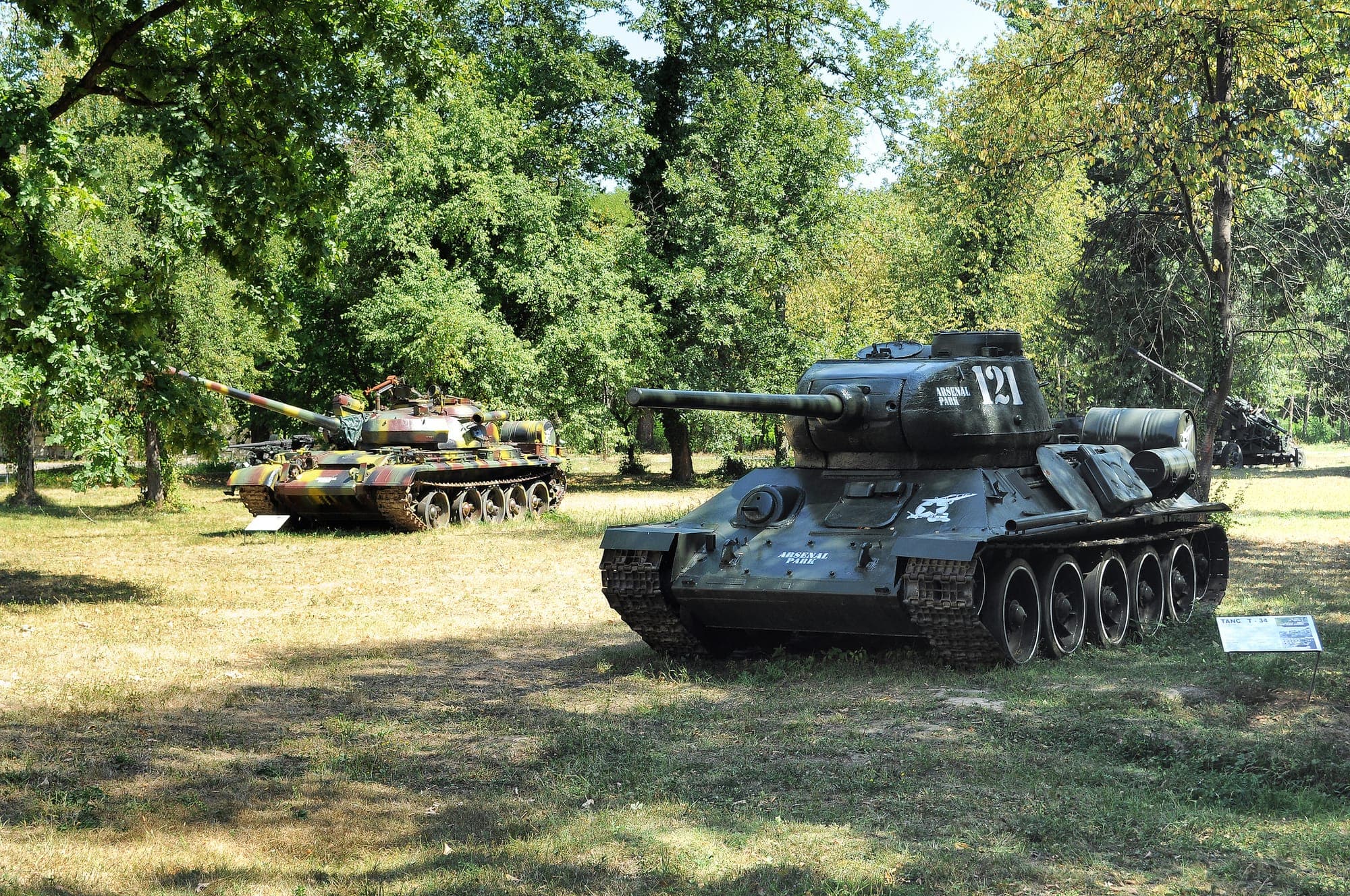 I carri armati T-34-85 e T-55 esposti in una radura tra gli alberi del parco, nel museo militare all'aperto