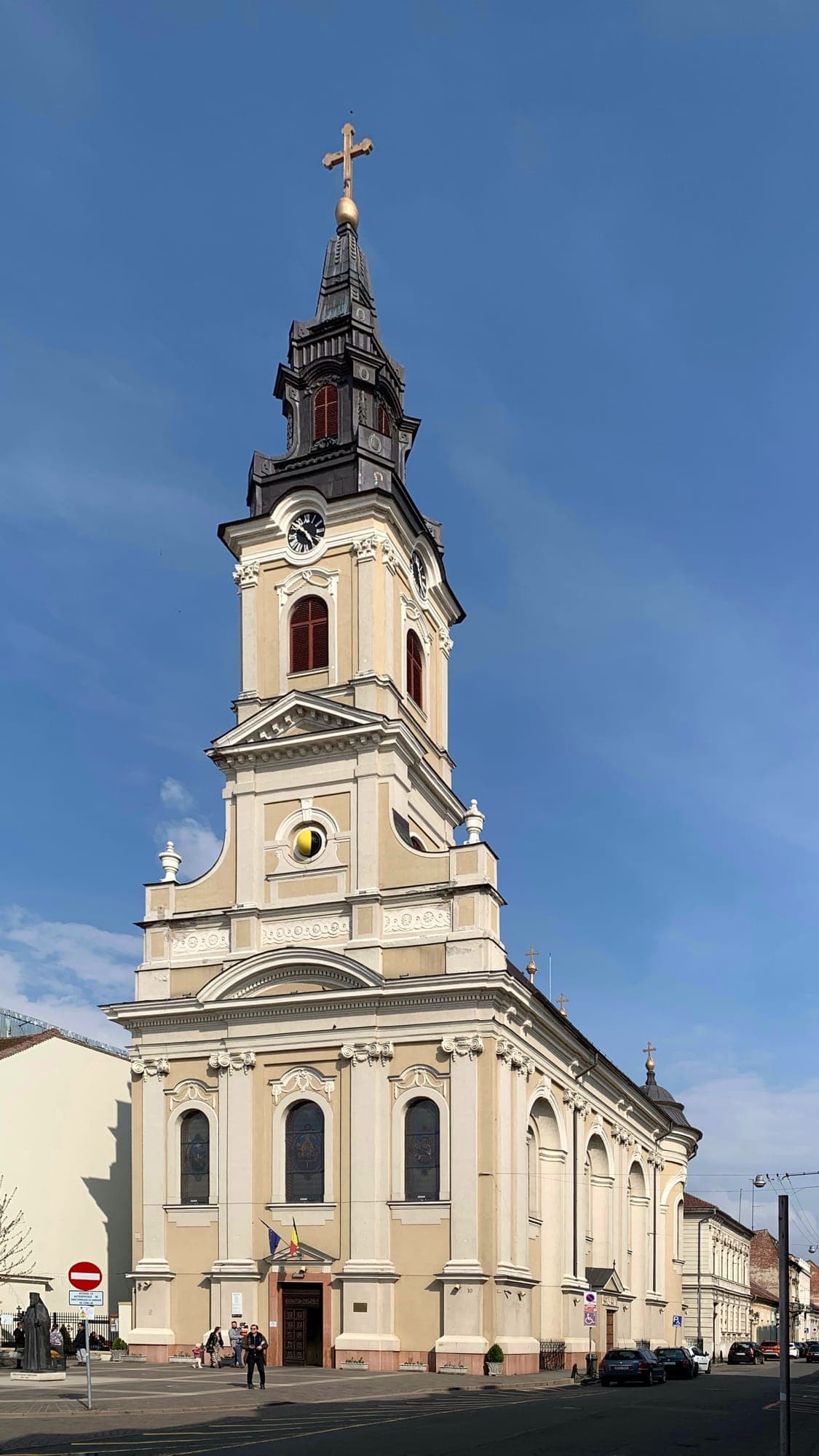 La facciata e la torre della chiesa, con l'orologio e il globo lunare nero e oro sotto di esso, contro un cielo azzurro