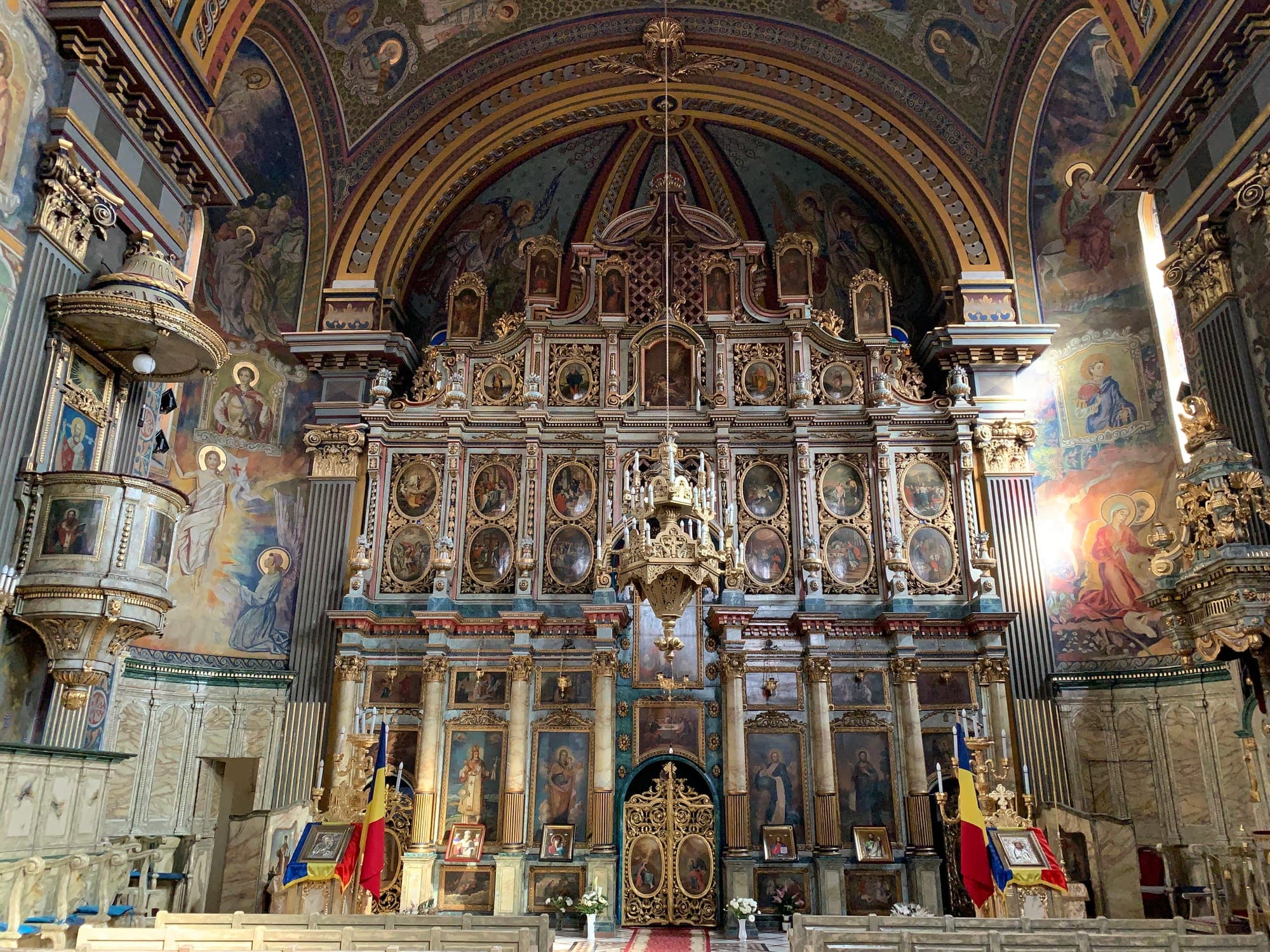 La pittura murale nella navata, con l'ingresso di Cristo a Gerusalemme, e una vetrata nell'arco sopra