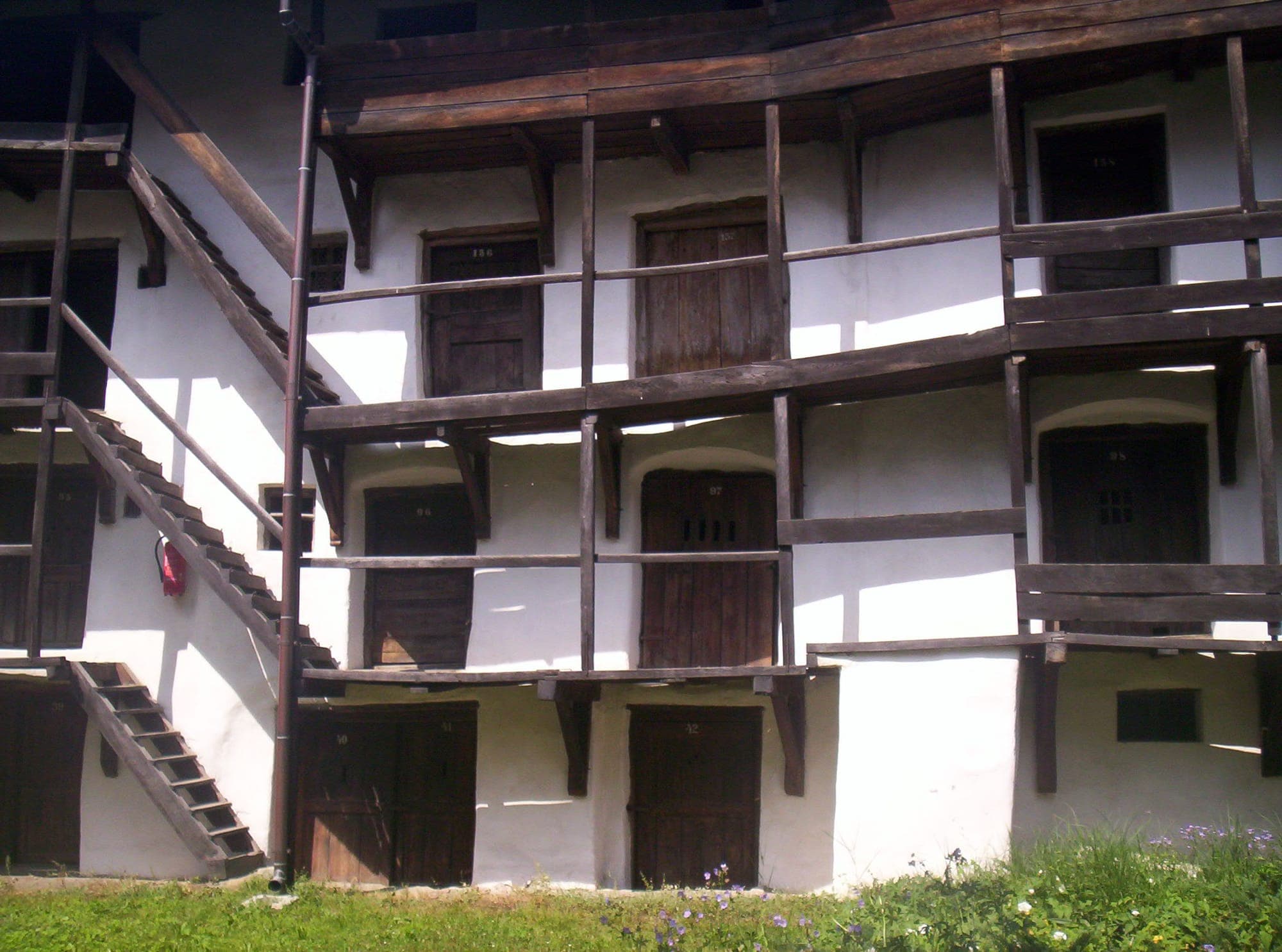 Numbered wooden doors of the storerooms on three levels, linked by timber galleries and stairs