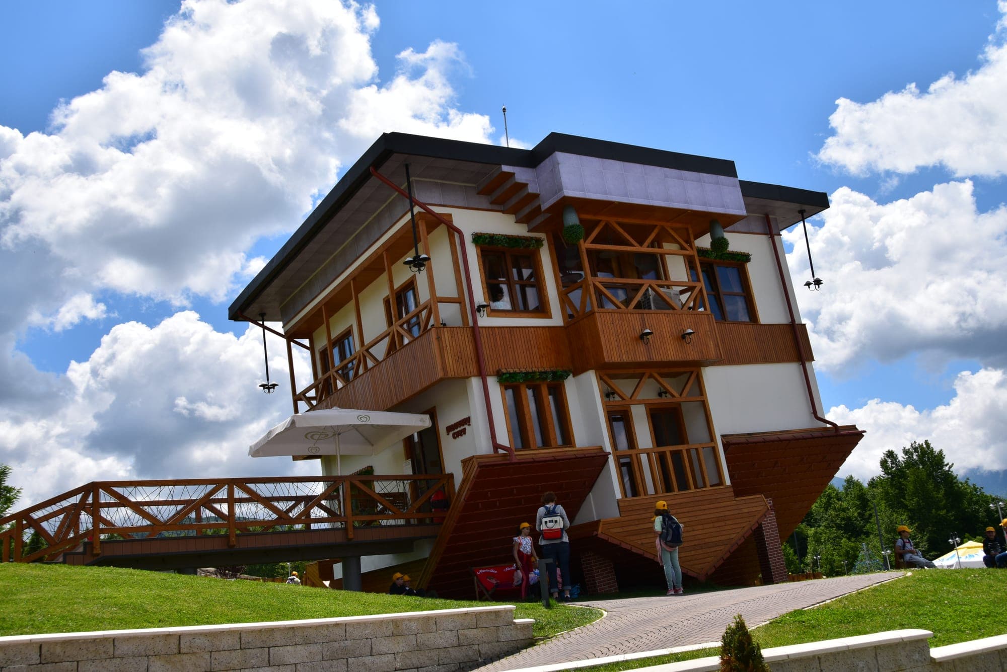 Das Haus auf dem Kopf aus anderem Blickwinkel, mit dem Holzsteg und der Eingangstreppe an der „Decke“