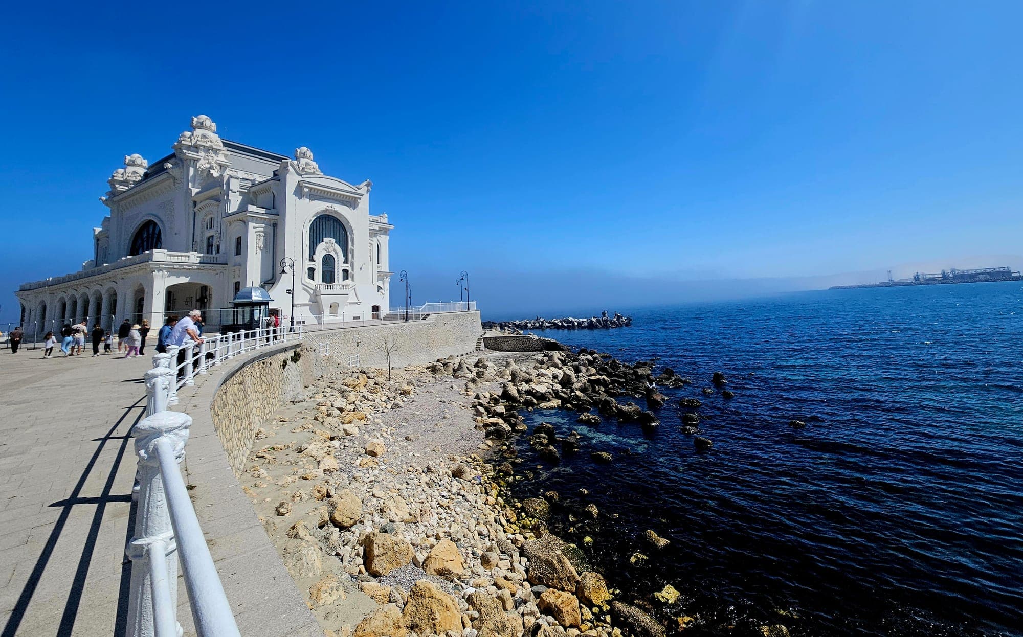The Casino seen from the seafront promenade, with the rocky shore and the blue sea on the right