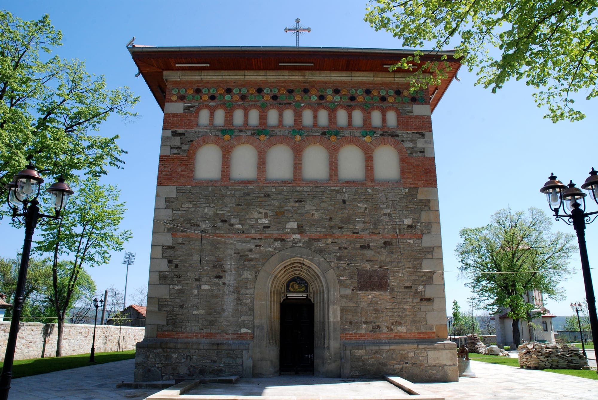 Die Westfassade der Kirche mit gotischem Portal und Reihen von Blendarkaden und Keramikscheiben