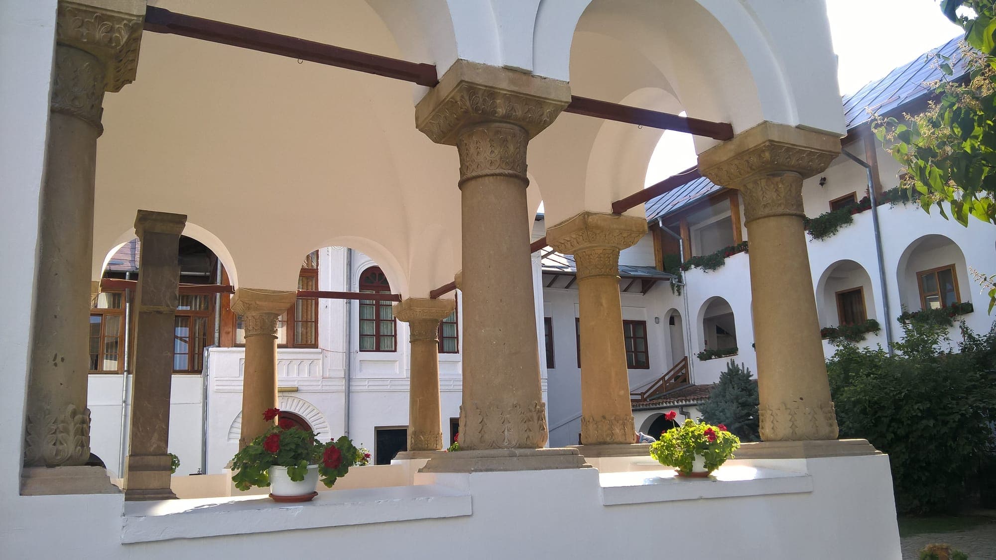 The carved columns of the porch, looking onto the inner courtyard and the arcaded buildings