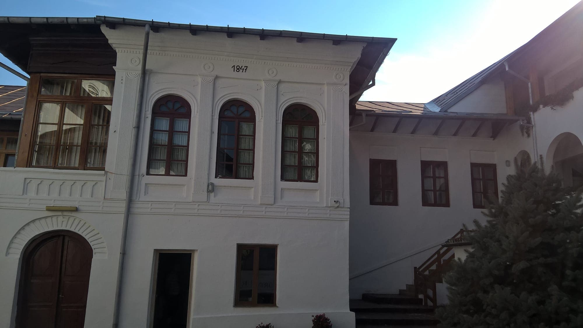 The block of cells with a white façade and the year 1847 above the windows, in the monastery courtyard