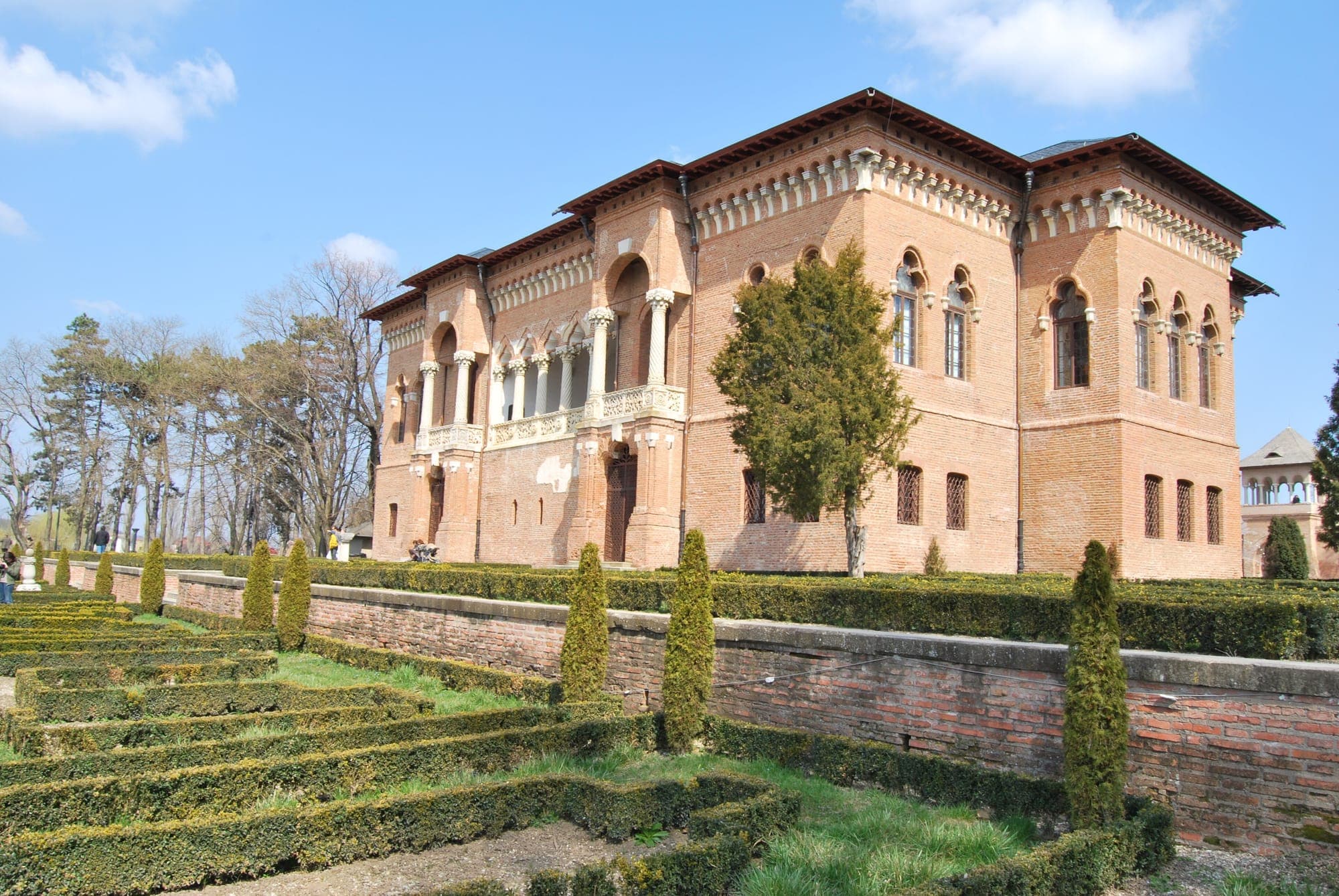 Palatul din cărămidă, cu loggia de pe fațada dinspre lac, văzut din grădina italiană cu gard viu tuns