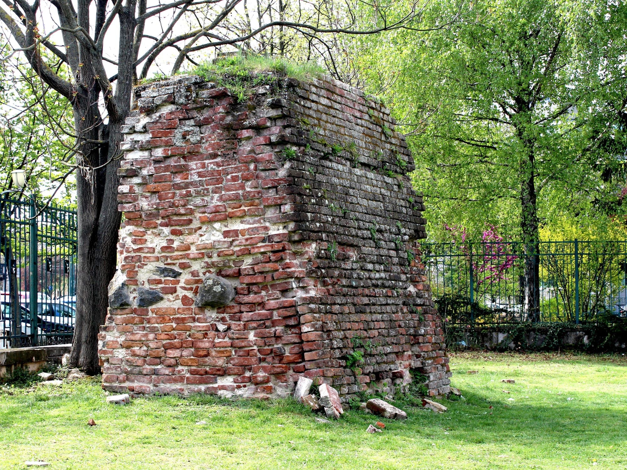 A fragment of brick wall from Timișoara's former fortress, preserved on the lawn among trees in the Botanical Park