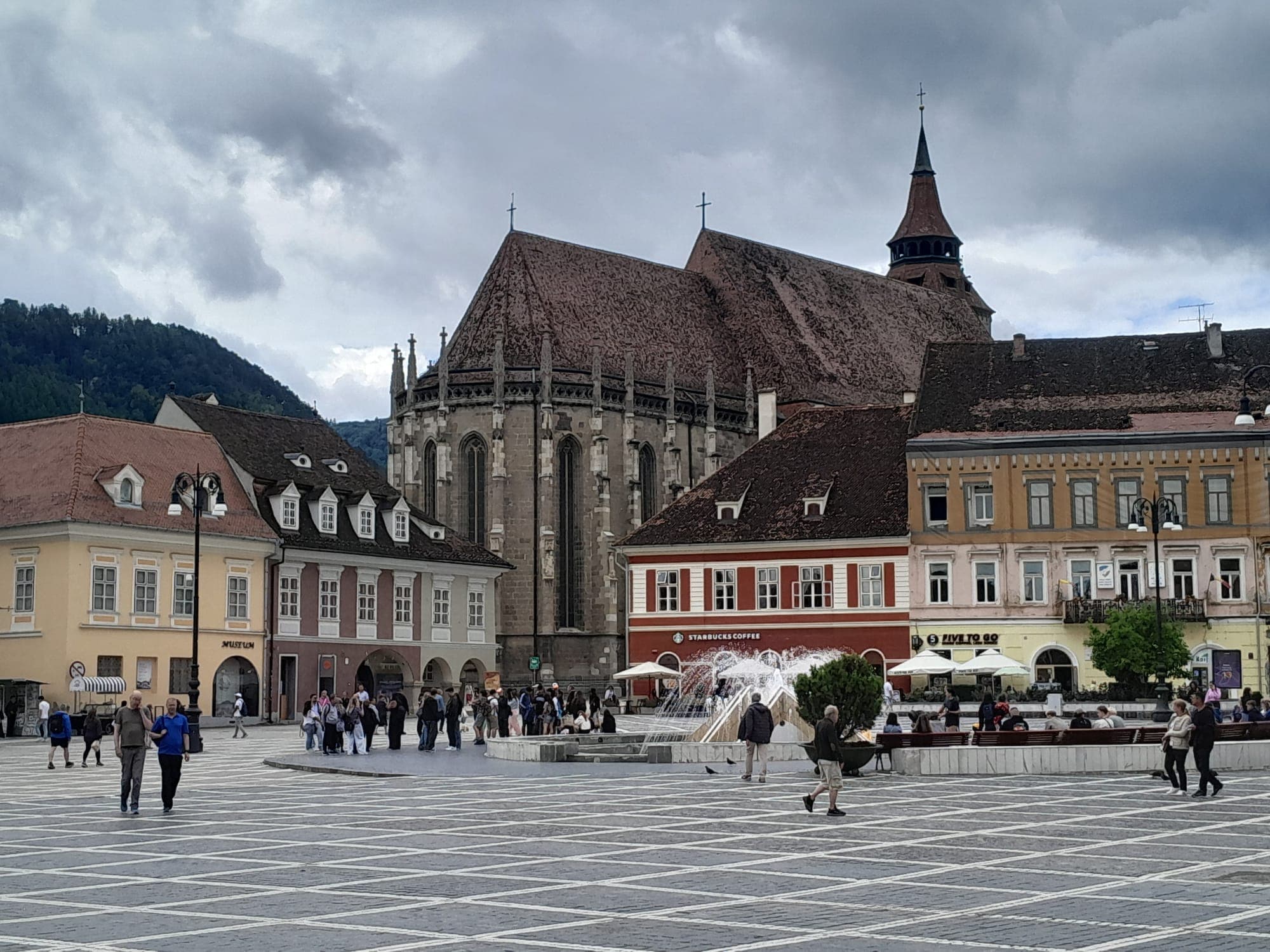 Biserica Neagră ridicându-se deasupra caselor din colțul de sud-vest al pieței, cu fântâna arteziană în față