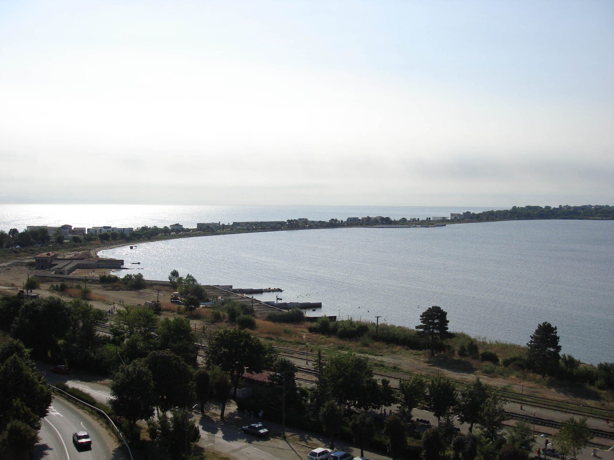 Lacul Techirghiol văzut de sus, cu fâșia de uscat și clădirile din Eforie Nord care îl despart de mare, iar în prim-plan calea ferată și șoseaua de pe mal